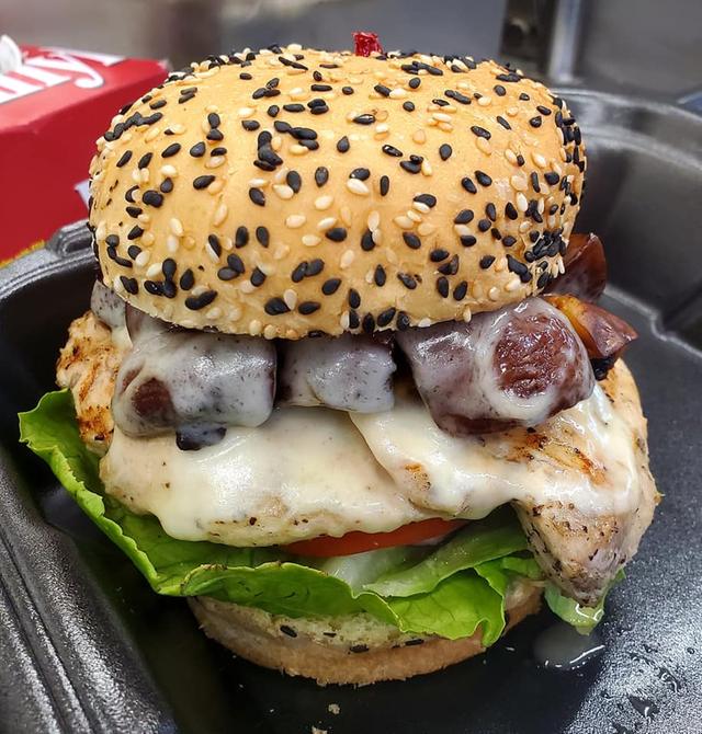 Specialty burger on a black-sesame bun with lettuce and tomato