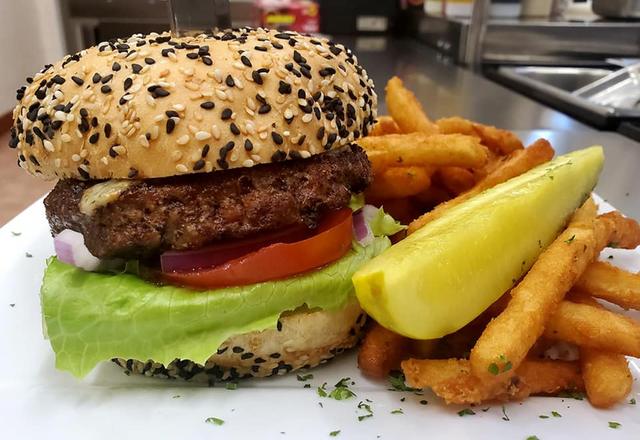 Burger and fries with a pickle spear